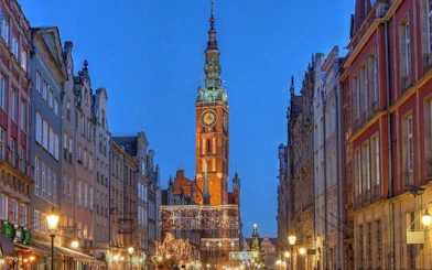 Gdansk Town Hall illuminated at dusk on a self-guided audio walking tour.