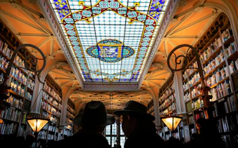 Stained glass ceiling and bookshelves in Livraria Lello, Porto Historic Center.