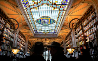 Stained glass ceiling and bookshelves in Livraria Lello, Porto Historic Center.
