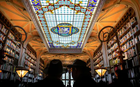 Stained glass ceiling and bookshelves in Livraria Lello, Porto Historic Center.