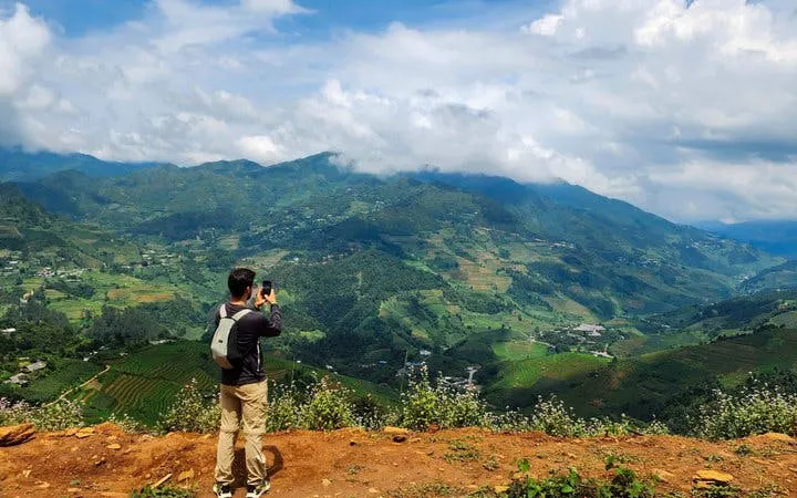 Trekker photographing terraced rice fields in Mu Cang Chai, Vietnam.