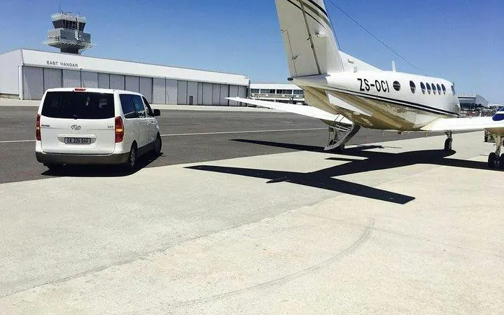Van and private plane at Cape Town International Airport runway.