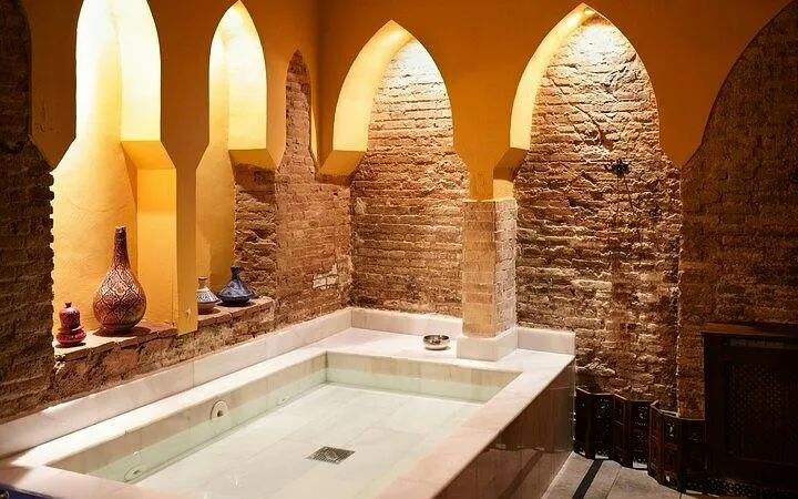 Authentic Moroccan hammam interior with arched niches and decorative vases in Marrakesh.