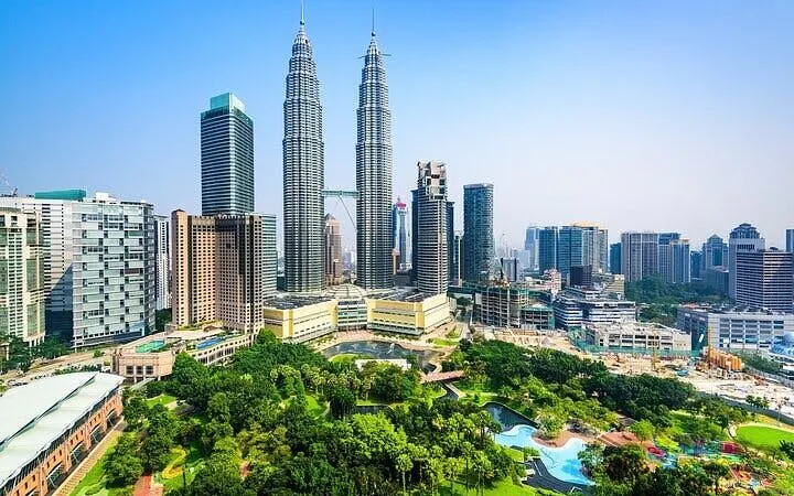 Petronas Towers and Kuala Lumpur skyline with lush park in foreground.