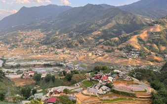 Terraced rice fields and village houses in Cat Cat Village, Sa Pa, with mountain backdrop.