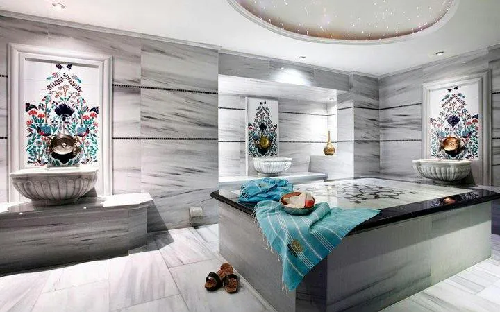 Turkish bath interior with marble surfaces, decorative tiles, and towels in Istanbul.
