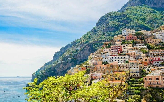 Amalfi Coast hillside village with colorful buildings and sea view.