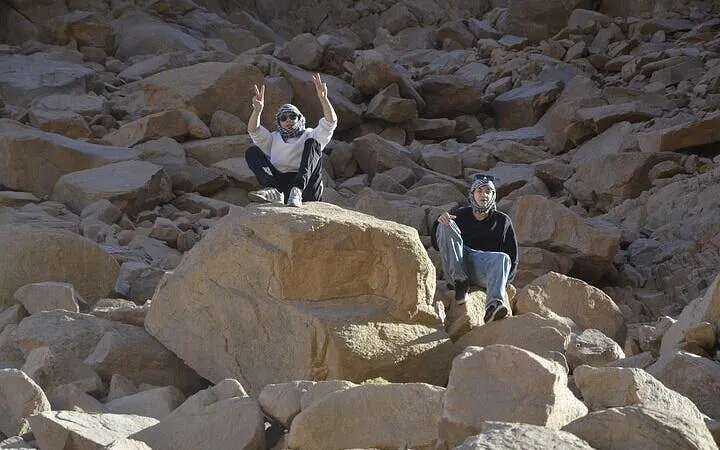 Two people sitting on rocks during a desert safari in Sharm El Sheikh's Echo Valley.