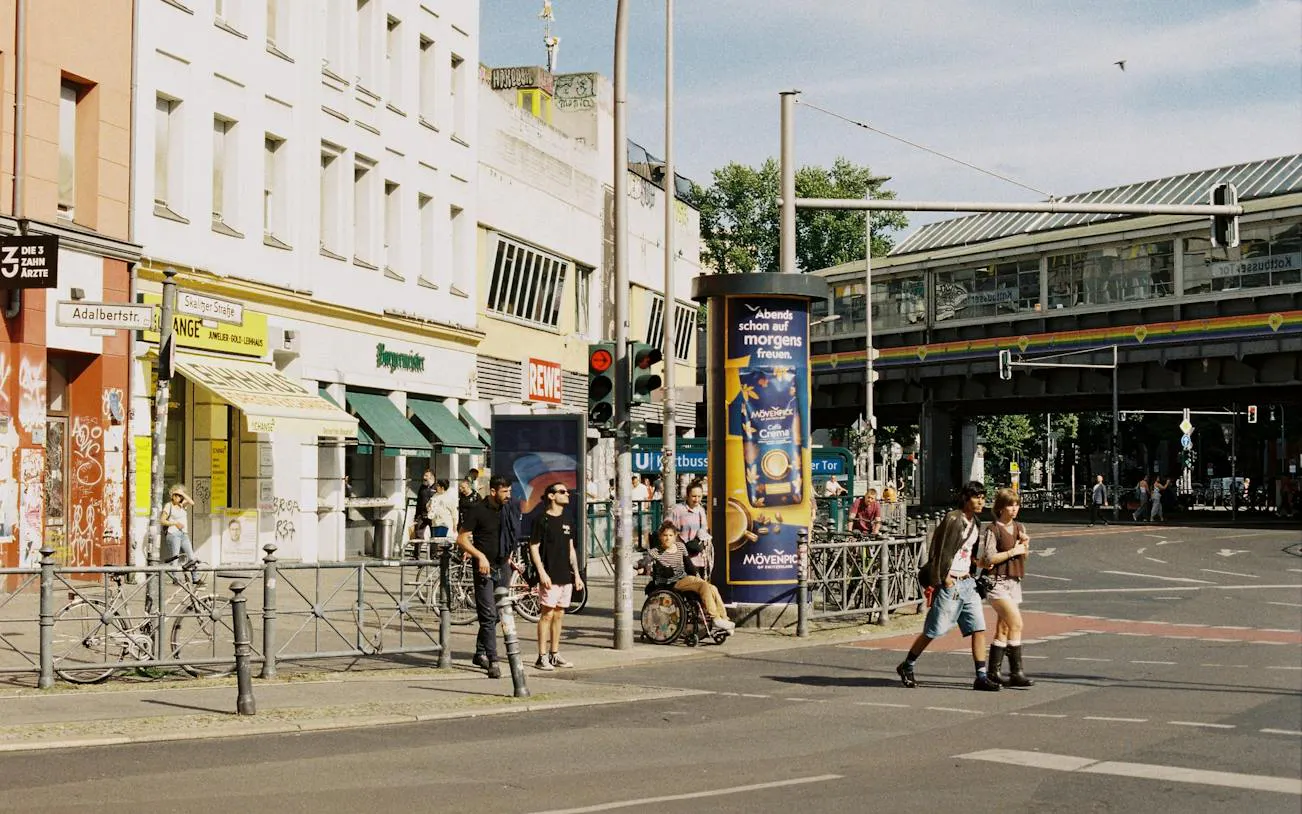 Street scene in Kreuzberg, Berlin with pedestrians near Kottbusser Tor station.