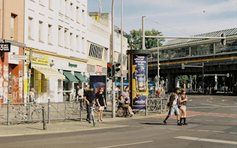 Street scene in Kreuzberg, Berlin with pedestrians near Kottbusser Tor station.