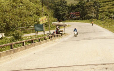 Motorbike on rural road near Bac Ha Market, Sapa, with roadside vendor stand.