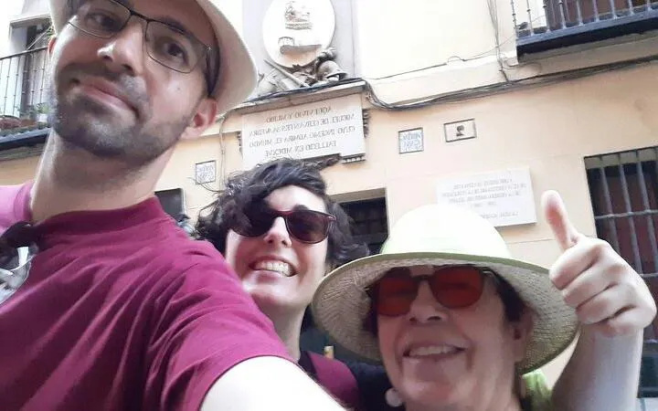 Self-guided tour participants in front of a historic plaque in Madrid, part of Don Quixote's exploration game.