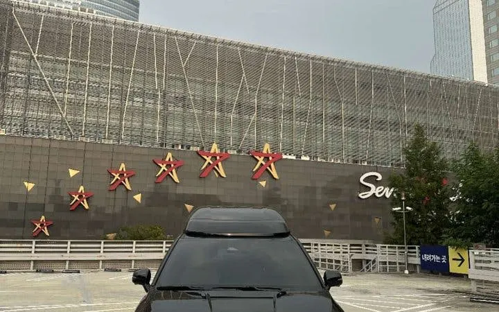 Black car parked in front of Starfield COEX Mall in Seoul, Korea, part of a private city tour.