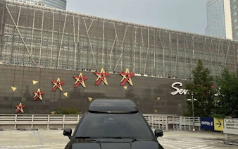 Black car parked in front of Starfield COEX Mall in Seoul, Korea, part of a private city tour.