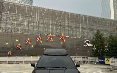 Black car parked in front of Starfield COEX Mall in Seoul, Korea, part of a private city tour.