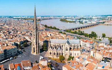 Aerial view of Bordeaux's Old Town with Saint-Michel Basilica and Garonne River.