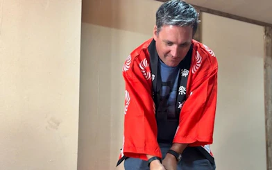 Traditional mochi pounding in red kimono during hands-on experience.