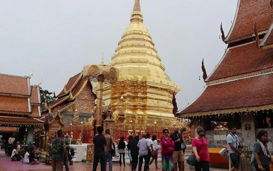 Doi Suthep Temple golden stupa with visitors exploring the grounds, Chiang Mai.