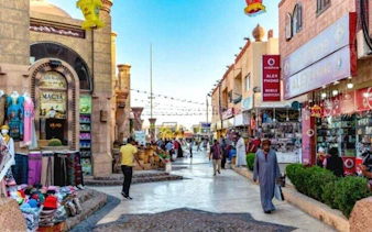 Bustling street in Soho Square, Sharm El Sheikh with shops and people walking.