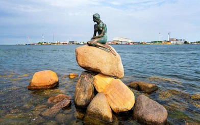 Little Mermaid statue on rocks by the water in Copenhagen.
