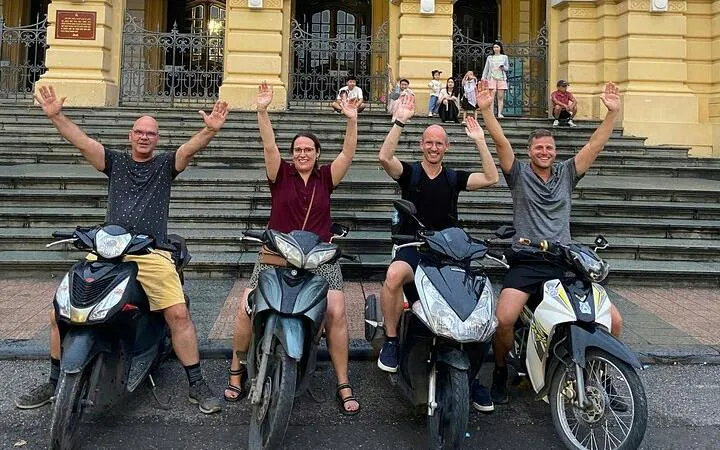 Tourists on motorbikes in front of Hanoi Opera House during night tour.