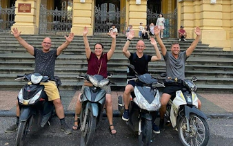 Tourists on motorbikes in front of Hanoi Opera House during night tour.