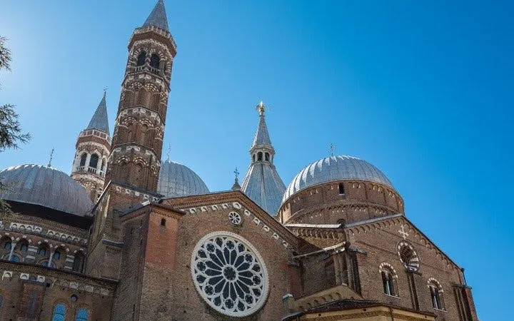 Basilica of Saint Anthony in Padua with domes and bell towers under clear sky.