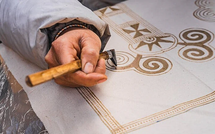 Local artisan creating H’Mong batik design with beeswax in Sa Pa workshop.