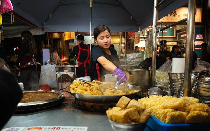 Street vendor cooking tofu at a Taipei night market during a local food tour.