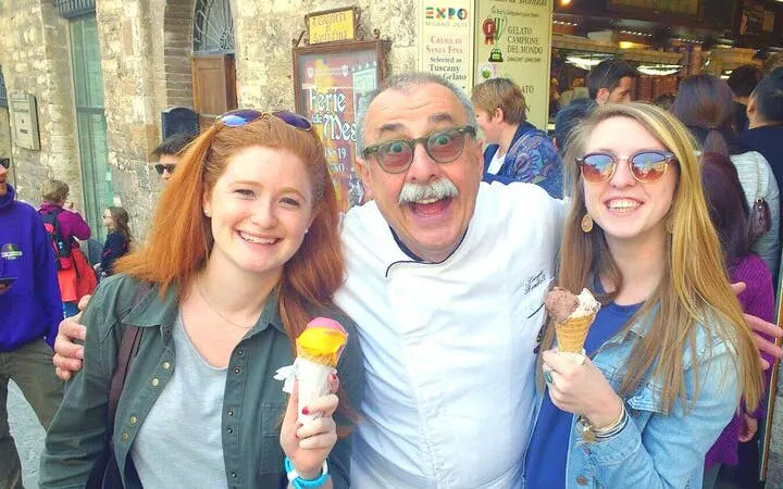 Tourists enjoying gelato with a local guide in San Gimignano during a Chianti wineries tour.