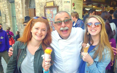 Tourists enjoying gelato with a local guide in San Gimignano during a Chianti wineries tour.