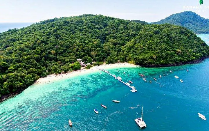 Aerial view of Banana Beach on Koh Hey with boats in turquoise water, Phuket.