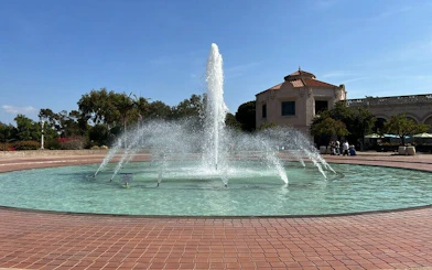 Fountain in Balboa Park, San Diego, with surrounding architecture and trees.