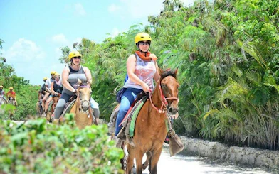 Horseback riders on a trail surrounded by lush greenery in Punta Cana.
