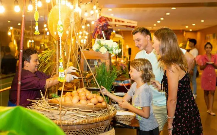 Family exploring food market at Siam Niramit Phuket Show, Phuket.