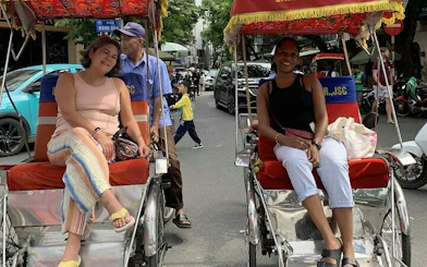 Cyclo tour in Hanoi's Old Quarter with passengers and driver on Train Street.