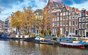 Canal houses and boats along Amsterdam's canal, part of a self-guided walking tour.