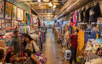 Market stalls with colorful textiles and souvenirs in Kuala Lumpur, part of Batu Caves tour.