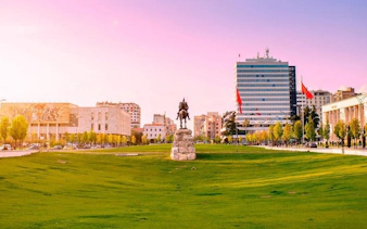 Skanderbeg Square in Tirana with statue and surrounding buildings.