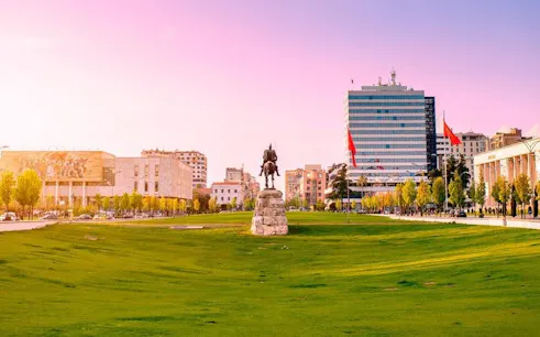 Skanderbeg Square in Tirana with statue and surrounding buildings.