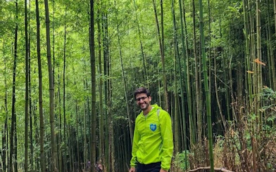 Man standing in lush bamboo forest during Mu Cang Chai motorbike tour.