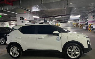 Private car in a parking garage for Sapa to Ha Giang City transfer with local driver insights.