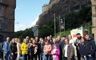 Group on Harry Potter walking tour in Edinburgh near historic castle.