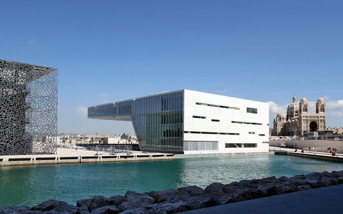 Modern architecture and historic cathedral by the sea in Marseille, France.