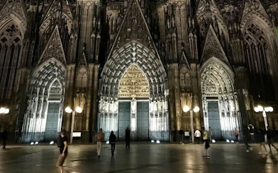 Cologne Cathedral illuminated at night during self-guided haunted city exploration game.