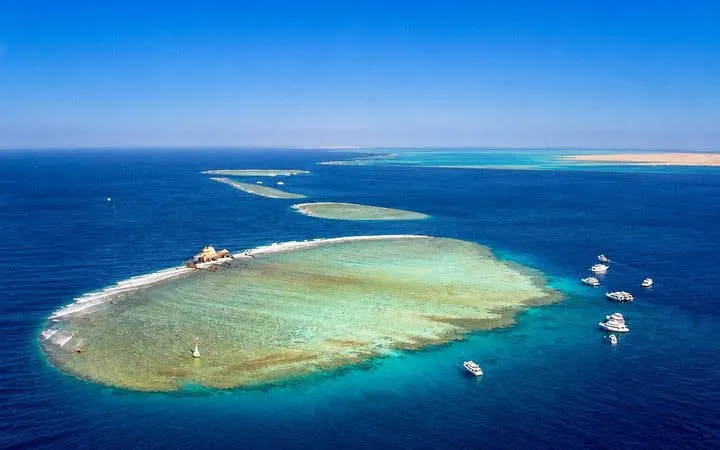 Tiran Island aerial view with boats, coral reefs, and clear waters, Sharm El-Sheikh snorkeling trip.