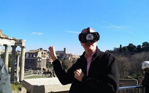 Man using VR headset at Roman Forum during private bike tour in Rome.