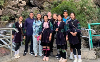Group of tourists with local guides on Sapa Private Car Tour near rocky landscape.