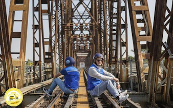 Vespa riders on Long Bien Bridge during Hanoi countryside tour to Bat Trang Ceramic Village.