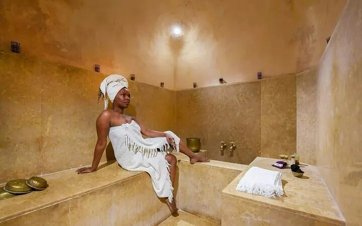 Authentic Moroccan hammam interior with person relaxing, Marrakesh.